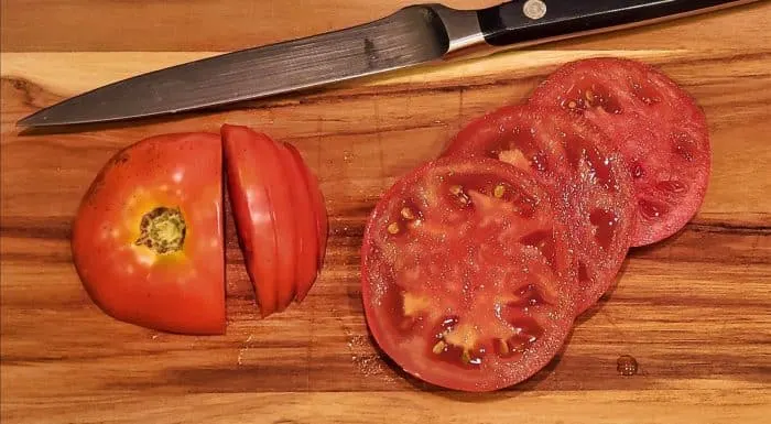 Tomato slices on a wooden cutting board