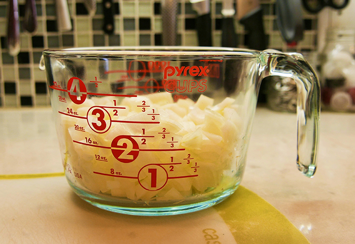 Pyrex measuring cup filled with onions