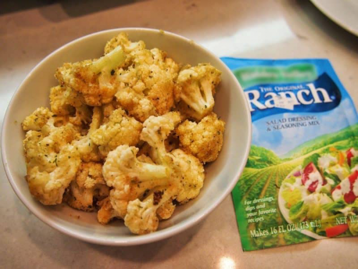 roasted ranch cauliflower in a bowl next toa pouch of ranch mix