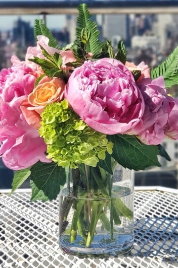 Flowers in a vase on a table outside.