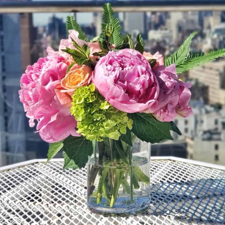 Flowers in a vase on a table outside.