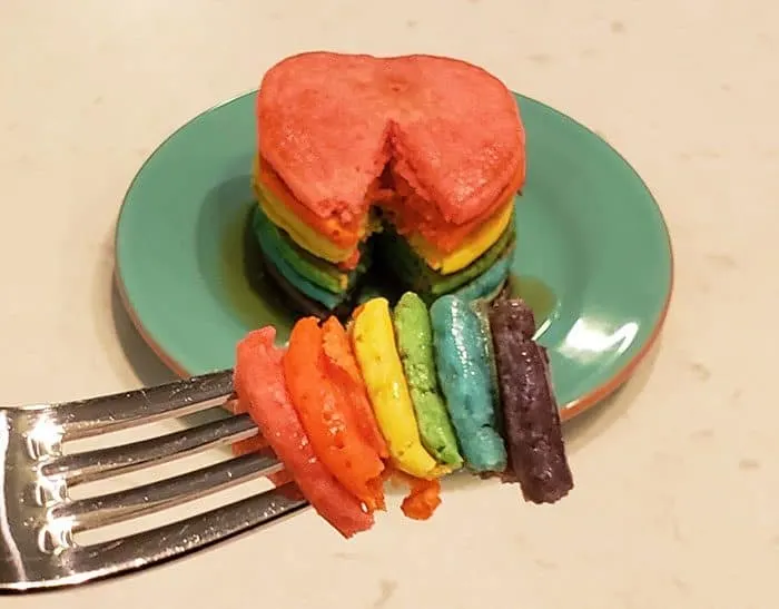 Six rainbow triangles of pancake on a fork