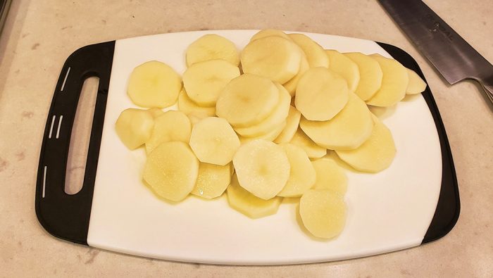 Sliced potatoes on a cutting board.