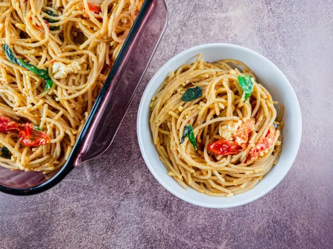 Bowl of spaghetti with tomatoes and basil.