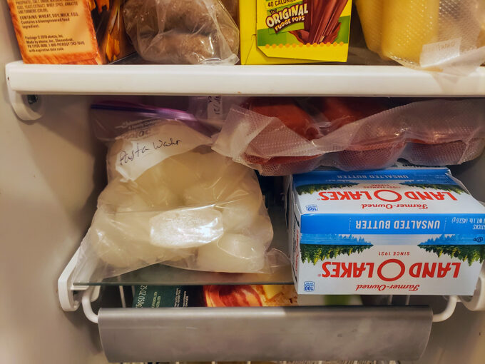 A baggie of pasta water cubes in the freezer.