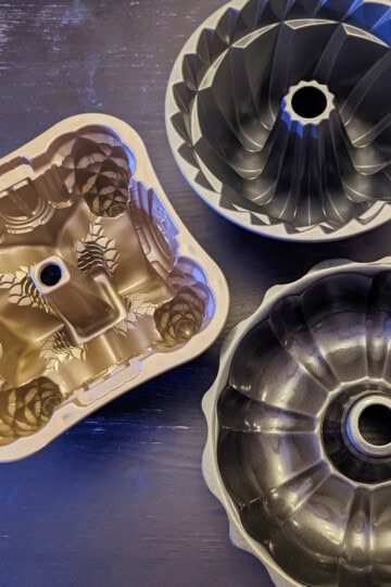 Three bundt pans with intricate designs.