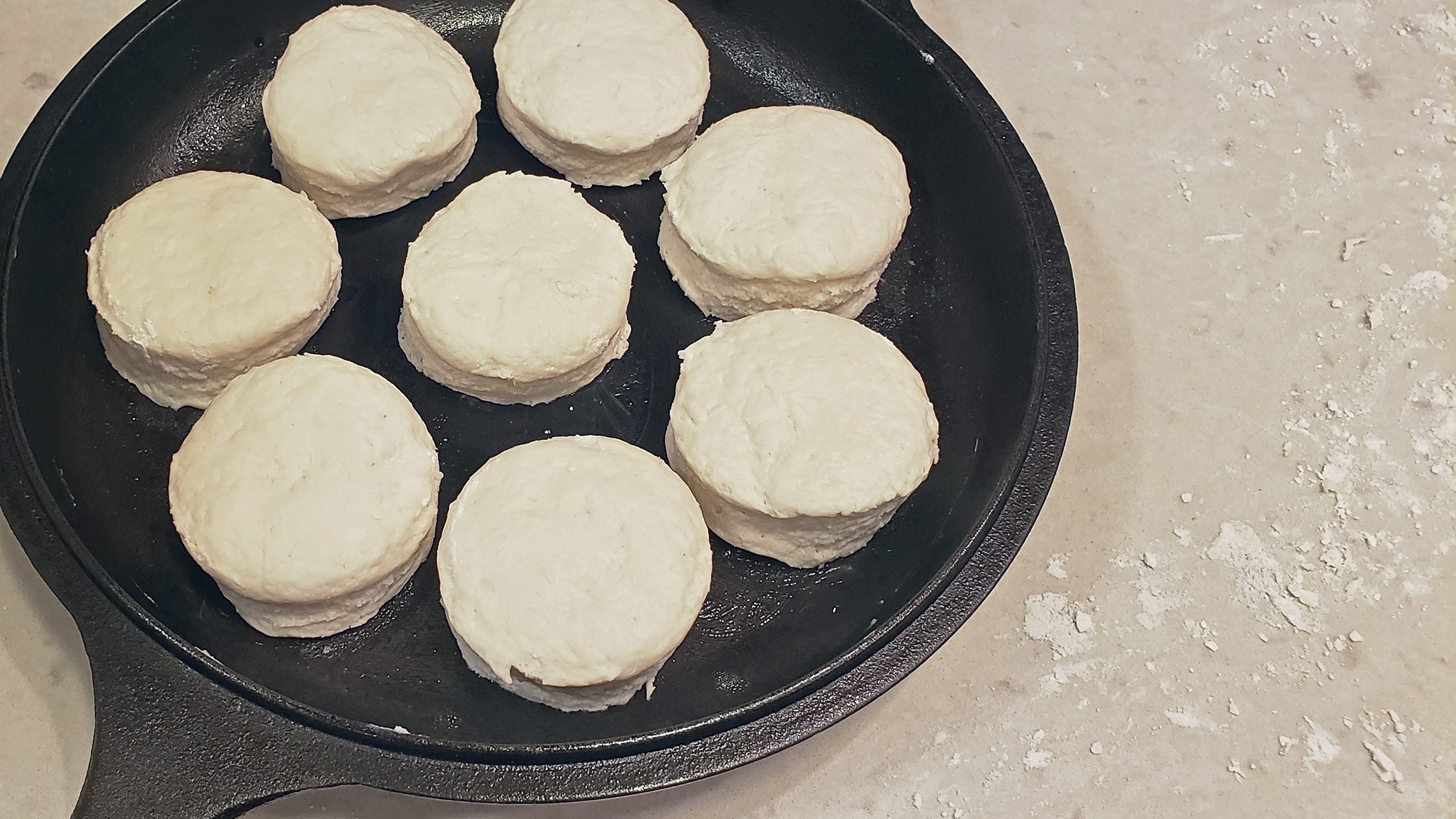 Cut biscuit dough in a cast-iron pan.