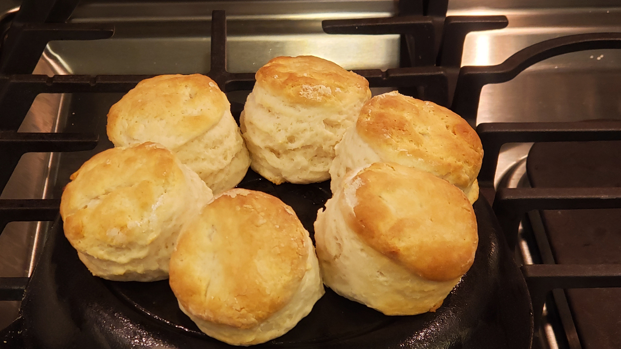 Lopsided biscuits on the back of a cast-iron pan.