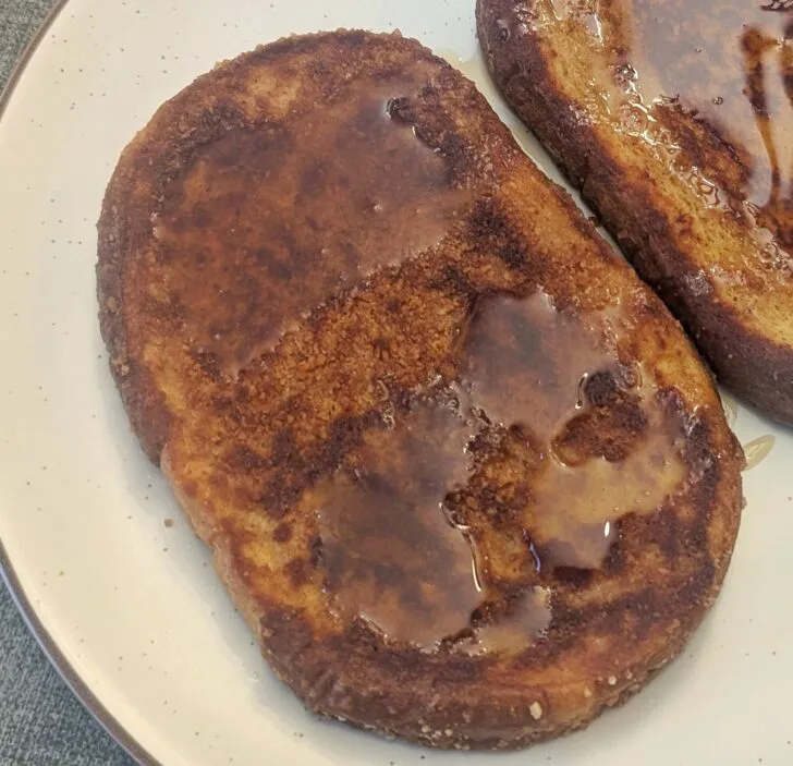 Close up of a slice of Cinnamon Toast Crunch French Toast on a plate.